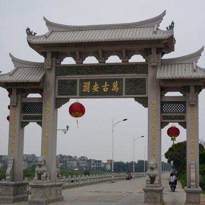 村口擺放青石雕刻仿古三門(mén)石牌坊